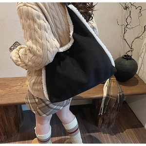 Détail du sac cabas noir minimaliste avec bordure en fausse fourrure blanche et volume