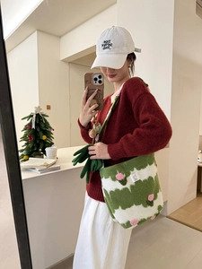 Detail of green and white plush knit tote bag with pink 3D flower decorative accents