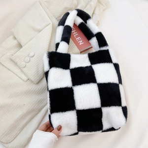 Close-up of black and white checkered plush handbag with soft faux fur texture