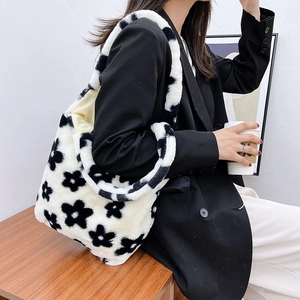 Detail of plush tote bag with black flower patterns and spacious cream fuzzy texture