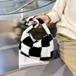 Close-up of fluffy black and white checkerboard plush handbag texture and soft handle