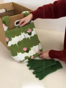 Detailed view of green wavy knit bag with pink floral accents and matching gloves