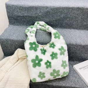 Dettaglio della borsa a spalla in morbido peluche con stampe floreali verdi e clip in metallo