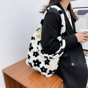 Detailed texture of white plush tote bag with black flower print and soft faux fur