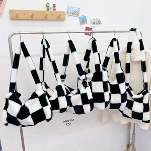 Close-up of black and white checkered faux fur tote bags displayed on a steel rack