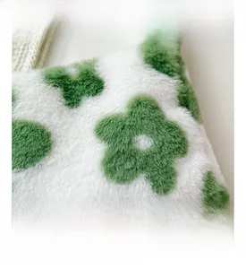 Gros plan détaillé sur la fausse fourrure douce avec motif floral vert sur sac blanc