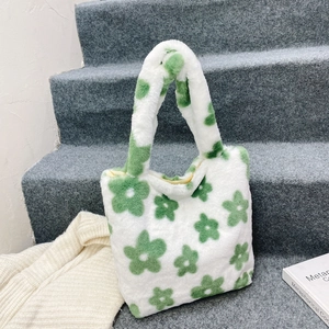 Detailed texture of white plush tote bag with green floral pattern on staircase