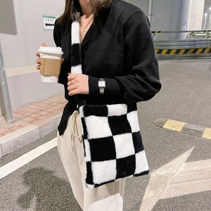 Detail of soft black and white checkerboard plush shoulder bag with wide strap