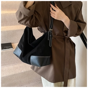 Detail of black matte PU tote bag with white contrast stitching and shoulder strap