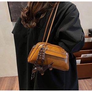Detail view of stylish brown rectangular PU shoulder bag with cute charms and double zippers