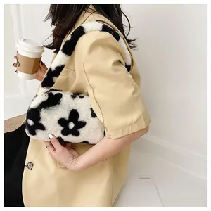 Detail of floral plush underarm bag showing contrast black and white faux fur texture