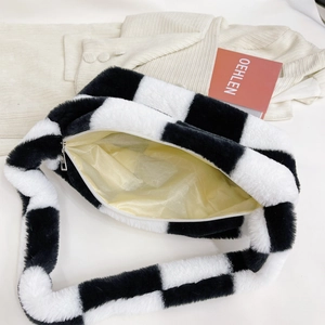 Detail of plush checkered handbag with smooth yellow lining and silver metal zipper closure