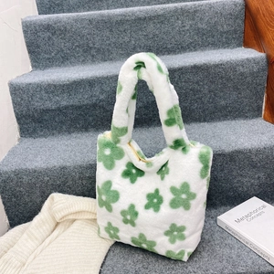 Close-up of fluffy tote bag with green floral patterns and soft plush texture detail