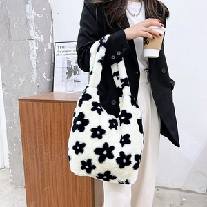 Detail view of plush tote bag with black flower pattern on white faux fur material