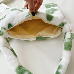 Detail of plush floral bag showing yellow fabric lining and smooth metal zipper closure