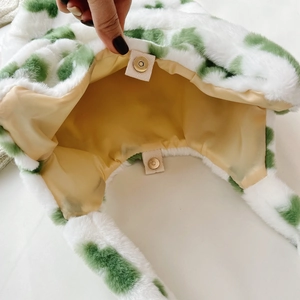 Dettaglio borsa di peluche a pois verdi con chiusura magnetica e fodera gialla