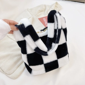 Gros plan d'un sac cabas en peluche à damier noir et blanc en fausse fourrure
