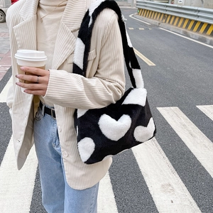 Gros plan du sac porté épaule en fausse fourrure avec motif cœur noir et blanc doux