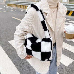 Street style view of soft plush checkerboard shoulder bag in black and white pattern