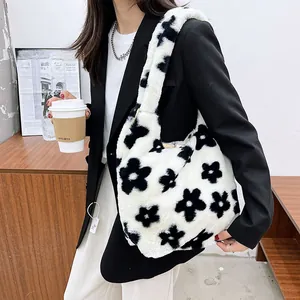 Furry tote bag with black and white floral pattern shown on a shoulder in lifestyle setting