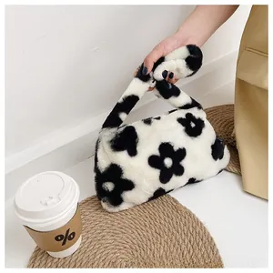 Détail de la texture pelucheuse et du motif floral noir sur ce sac à main en fourrure