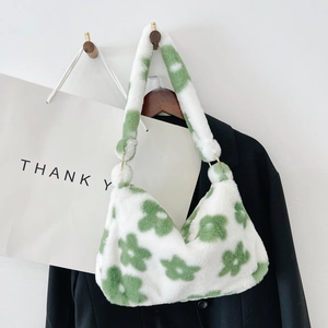Detailed close-up of fluffy plush shoulder bag featuring green floral patterns on white fur