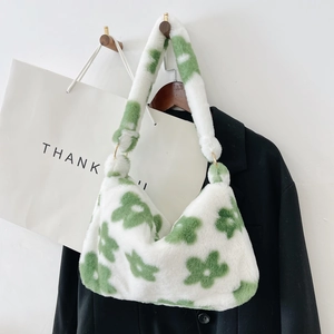 Close-up of white plush faux fur tote bag with green floral pattern and gold metal rings