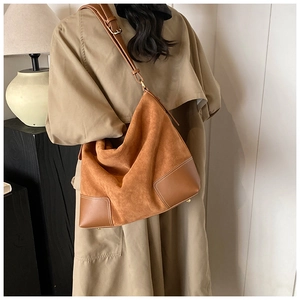 Detailed close-up of brown suede and smooth leather splicing with reinforced corner design