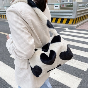 Détail du sac à bandoulière en peluche avec motif de cœur noir et blanc en fausse fourrure