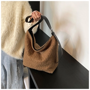 Close-up of brown plush faux fur tote bag with black leather adjustable shoulder strap