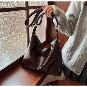 Détail d'un mannequin portant un sac fourre-tout en cuir PU marron foncé dans un cadre intérieur
