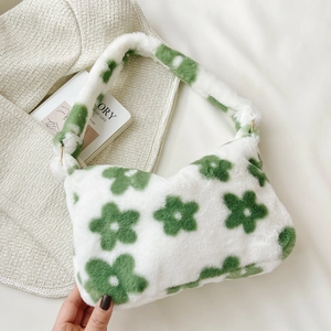 Close-up of soft plush handbag with green flower pattern on cream faux fur material