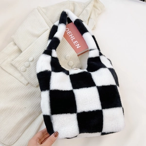 Gros plan du sac à main pelucheux à carreaux noir et blanc sur veste en velours