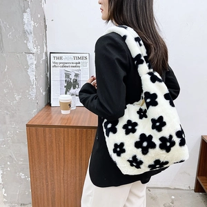 Detailed view of the soft faux fur texture and black floral pattern on the handbag