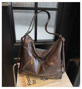 Detail of dark coffee brown PU leather bag with zipper pocket on vintage book background