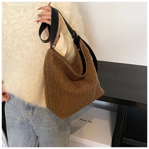 Brown teddy fur shoulder bucket bag with adjustable black leather strap shown on model