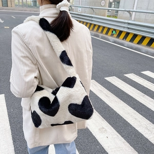Détail du sac à bandoulière en fausse fourrure douce avec motif de cœurs noir et blanc