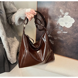 Détail d'un sac cabas en cuir PU marron chocolat brillant avec finition réfléchissante