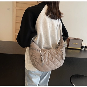 Detailed close-up of quilted rhombic texture and woven zipper puller on the hobo bag