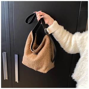 Detail of soft brown faux shearling tote bag with adjustable black leather shoulder strap