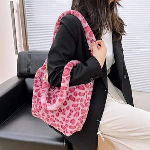 Detailed view of the soft pink leopard print plush tote bag worn over the shoulder