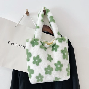 Close-up of plush faux fur tote bag with green flower pattern on white fuzzy material