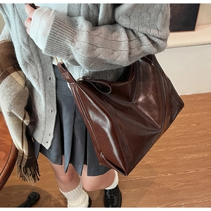 Gros plan sur un grand sac cabas en cuir PU marron foncé avec une large bandoulière