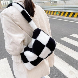 Detail of soft black and white checkerboard plush shoulder bag with wide strap