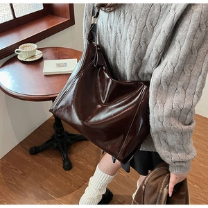 Détail d'un sac cabas en similicuir marron brillant avec logo GLEADY gaufré chic