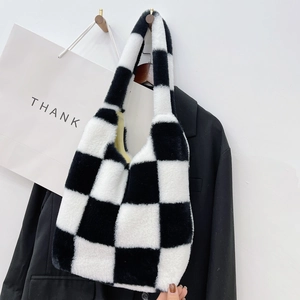 Gros plan du sac à main pelucheux à damier noir et blanc en fausse fourrure douce et texturée