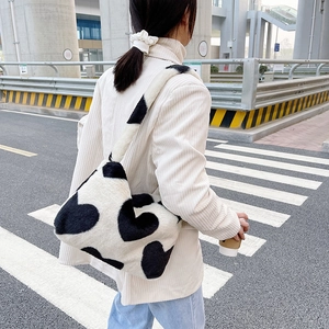 Vue détaillée du sac à bandoulière en peluche noir et blanc avec un grand motif de cœur