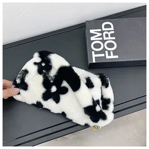 Detail of plush floral handbag with black and white flower pattern and gold zipper