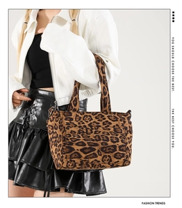 Detail of leopard print tote bag with front pocket and soft texture held by a model