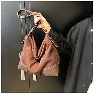 Detail of dark coffee suede Hobo bag with white contrast stitching and leather trim